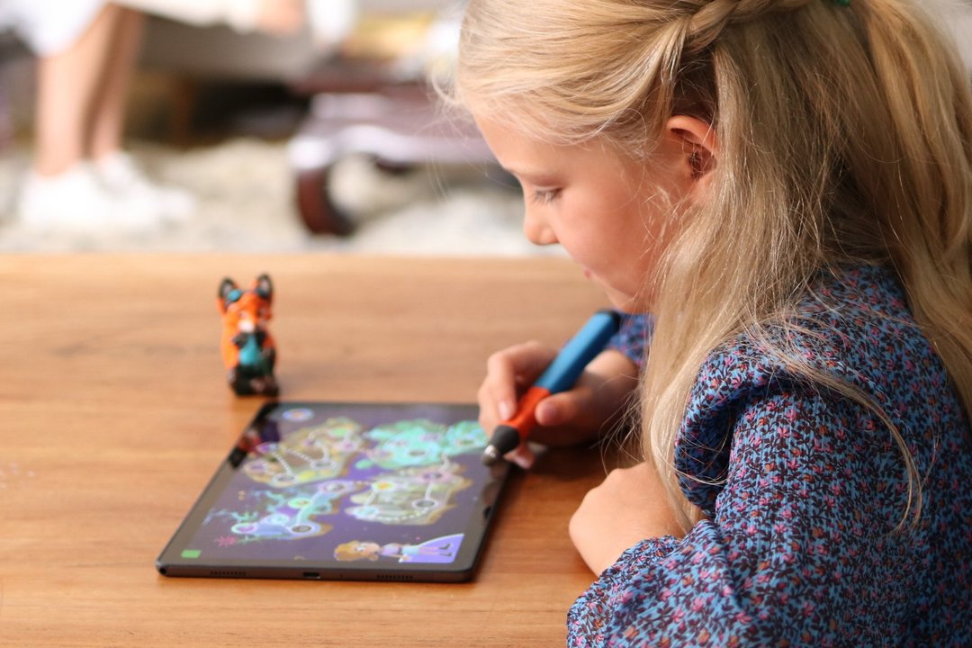 Ein Mädchen arbeitet konzentriert am Tablet, auf dem die EDURINO-App zu sehen ist