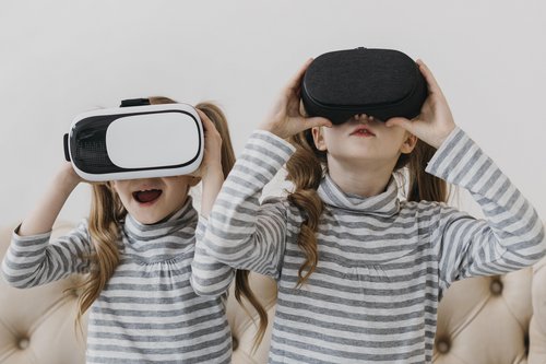 Zwei Mädchen schauen durch VR-Brillen und sind erstaunt. Ist das ein Zukunftszenario?